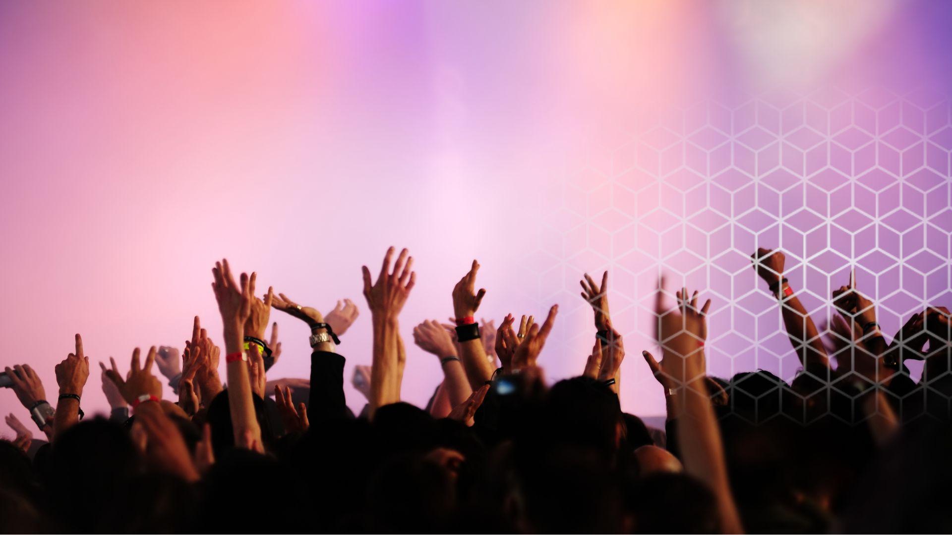 people at a concert put their hands in the air