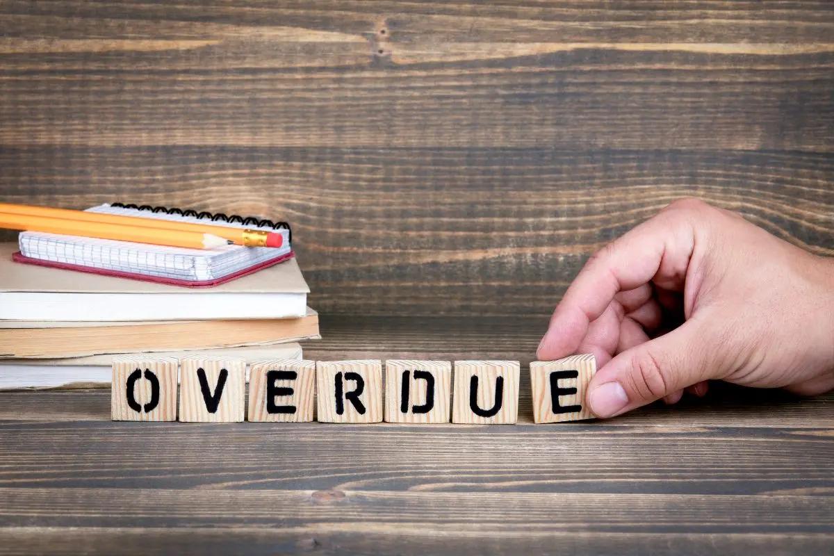 The word overdue spelled out with wooden blocks on a wooden background