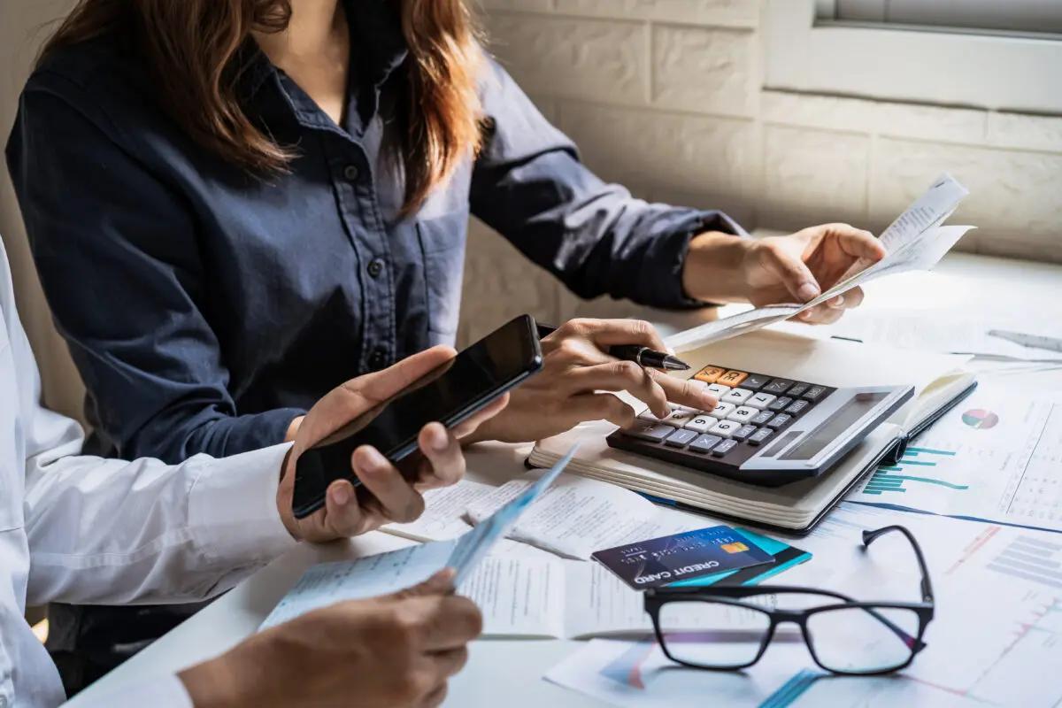 People sit at a table adding up their budget and their finances